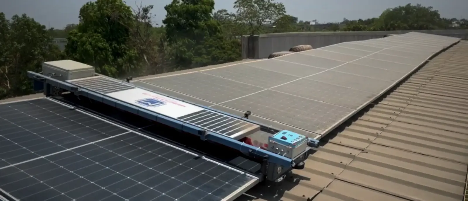 Solar Glide robot running along a long rooftop solar panel row