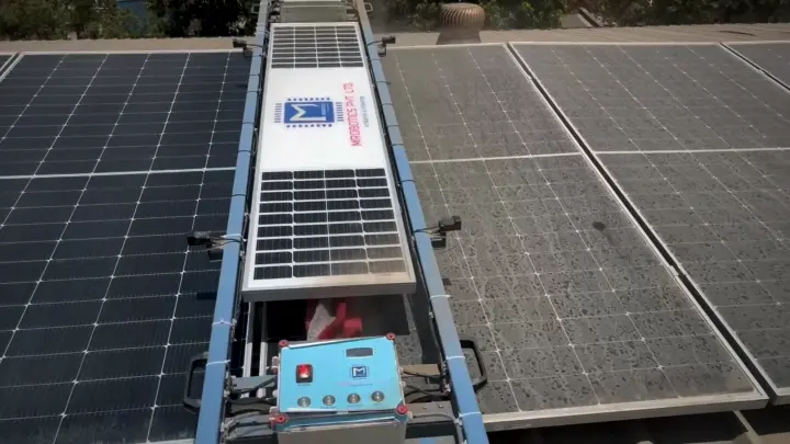 Solar Glide robot between clean panels on the left and dusty panels on the right