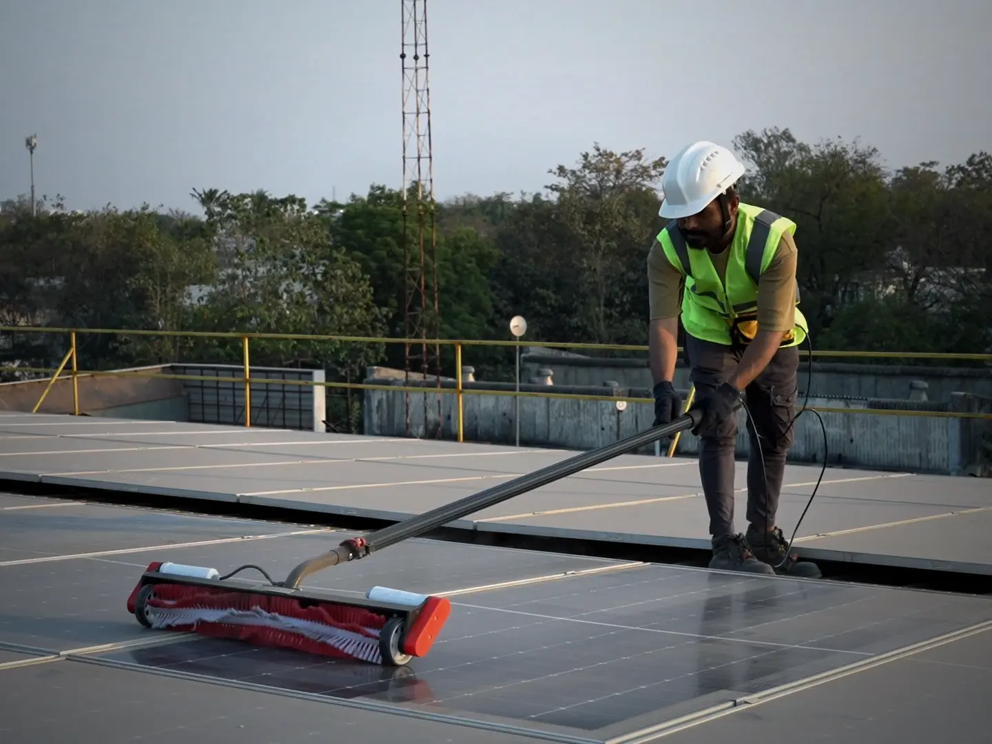Technician in safety gear using the Aqualess Industrial cleaner on a rooftop