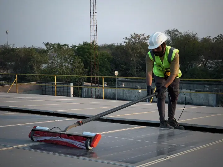 Technician in safety gear using the Aqualess Industrial cleaner on a rooftop